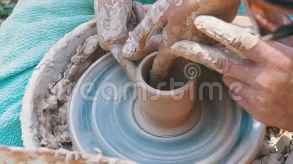 男人和女人陶工的手在陶工车轮上用粘土工作视频的预览图
