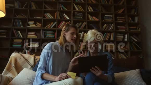 漂亮的女人和她年迈的母亲在网上付款视频的预览图