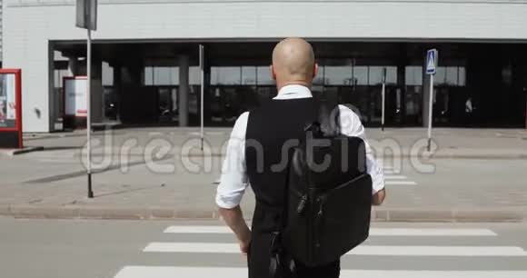 年轻时尚的秃头商人步行到商务中心机场办公室概念一项新业务周游世界视频的预览图