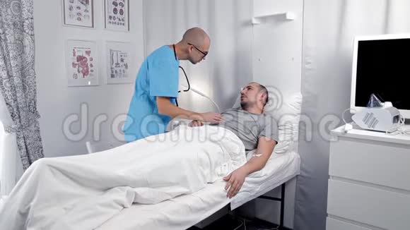 年轻男性病人在急诊室咨询医生检查病人并在笔记本上做笔记视频的预览图