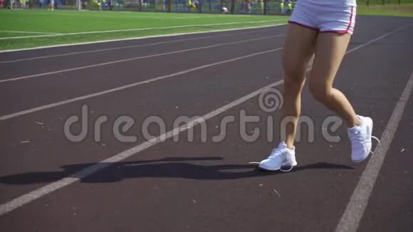 穿短裤的运动女孩把鞋带系在白色鞋带上视频的预览图