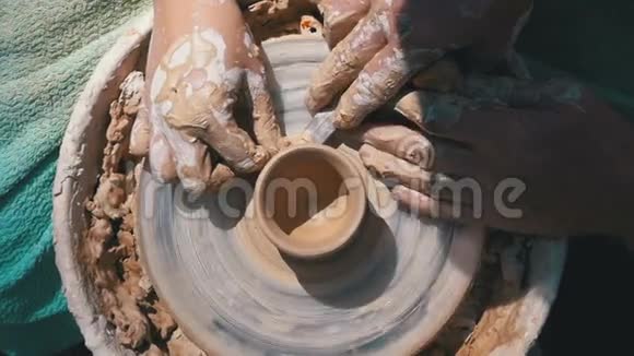在陶工的顶部视图他的手与粘土在陶工的车轮慢动作视频的预览图