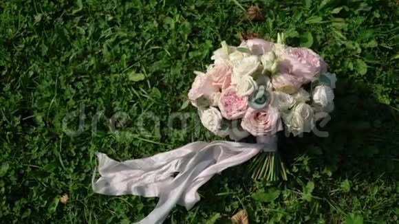 绿色草地上的粉色和白色玫瑰婚礼花束视频的预览图