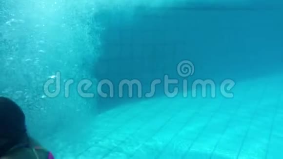 少女在度假酒店的水中游泳在游泳池里潜水视频的预览图