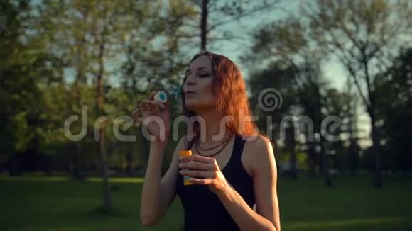 女性制造肥皂泡美丽的树有橙色的叶子视频的预览图