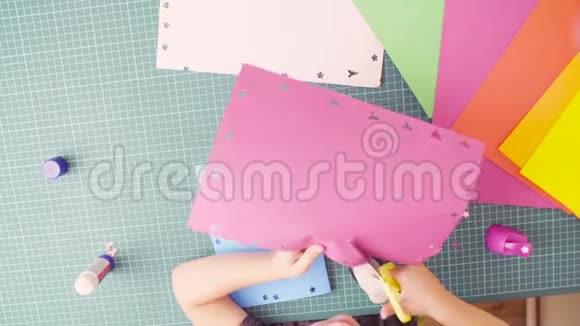 小女孩用剪刀剪彩纸的手视频的预览图
