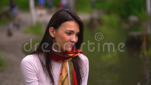 夏天美丽的年轻女子在湖边喂鸭子特写快乐的笑脸4千克视频的预览图