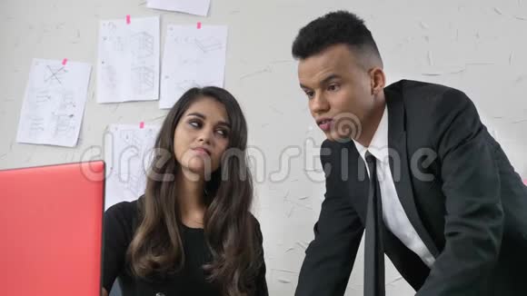 年轻女孩在办公室里和一个穿西装的员工调情轻轻地抚摸他的脸颊调情骚扰概念50视频的预览图