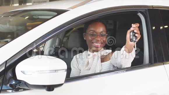 快乐的女人买新车在相机上显示钥匙成功的女商人视频的预览图