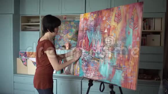 女艺术家在艺术工作室画一幅手的抽象画侧视4千克视频的预览图