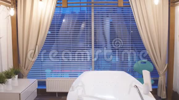 年轻迷人的男子穿着白色长袍休息在豪华水疗中心站在全景窗前的男人在一个视频的预览图