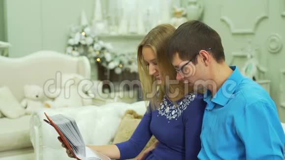 一对夫妇在相册中观看照片面带微笑视频的预览图