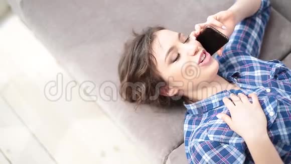 女孩躺在沙发上打电话视频的预览图