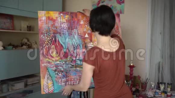 女艺术家转一幅抽象画女艺术家在艺术工作室画一幅抽象画4千克视频的预览图