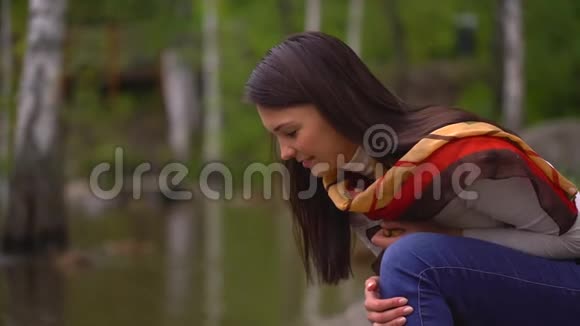 夏天美丽的年轻女子在湖边喂鸭子4千克视频的预览图