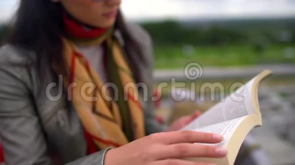 夏天年轻漂亮的女人坐在公园外面的长凳上看书合上书4千克视频的预览图
