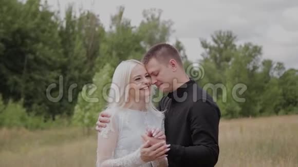 相爱的幸福夫妇站在田野上牵手视频的预览图