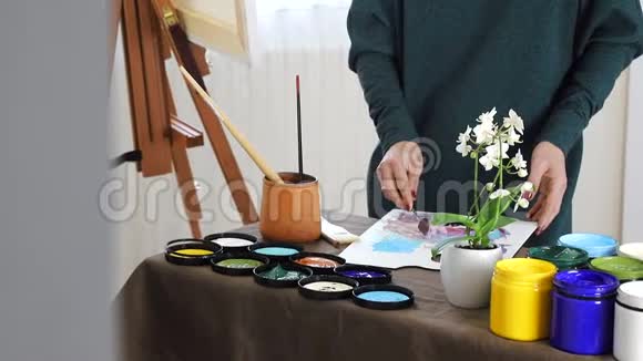 艺术家的女性手在黑板上混合颜色准备用丙烯酸颜料画一幅画视频的预览图