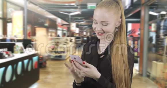 迷人的红发女人正在手机上阅读一条信息视频的预览图