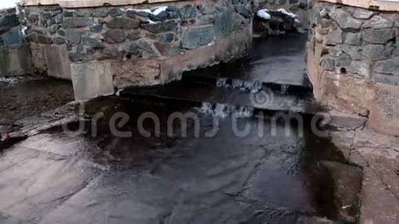 水从冬季公园的管道流入池塘视频的预览图