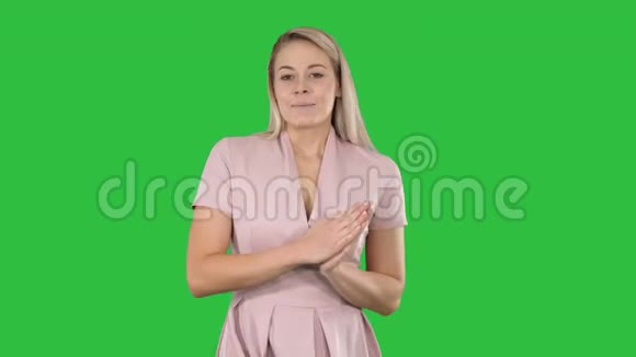 穿粉色衣服的女人在绿色屏幕上和摄像机说话Chroma键视频的预览图