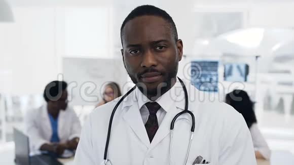 自信的非洲男医生在医院背景上有一队考克视频的预览图