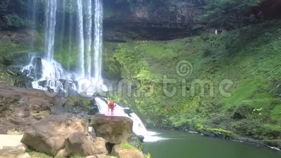公园瀑布式岩石上的上景女孩视频的预览图
