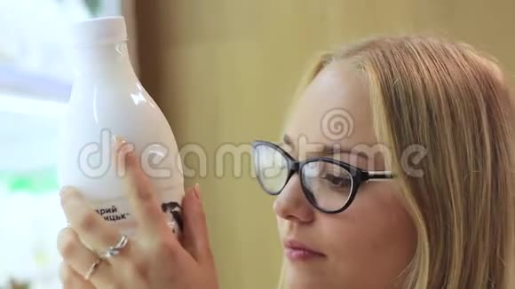 女孩正在考虑超市里放一瓶牛奶视频的预览图