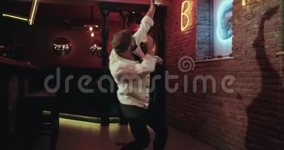 迷人的男人在酒吧里跳舞拿着智能手机拍照视频的预览图