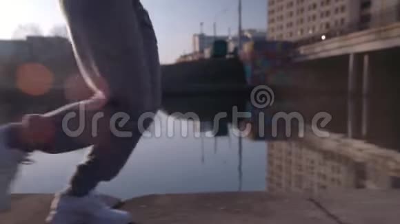 在美丽的日出中靠近城市里慢跑的女性脚视频的预览图