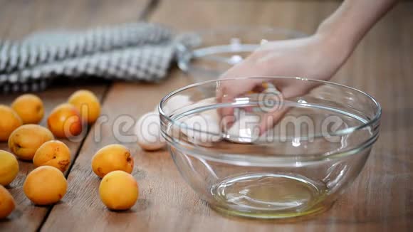 用女性手在金属不锈钢搅拌碗上分离出蛋黄白视频的预览图