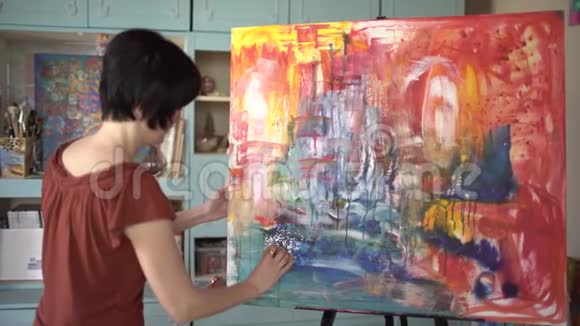 女艺术家在艺术工作室画一幅抽象画4千克视频的预览图