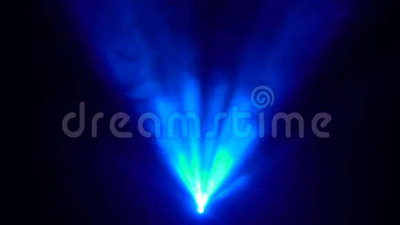 一盏探照灯在场景的中心向黑色背景照射蓝色烟雾视频的预览图