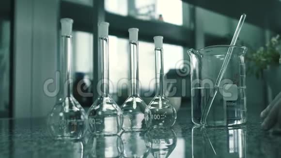 实验室的一张桌子上放着一个装有溶液的化学瓶和杯子视频的预览图