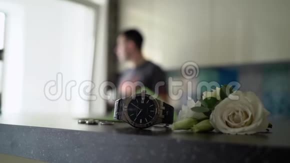 白玫瑰的腕表和布托尼埃阿米德男人或新郎喝茶或咖啡在后台吃早餐视频的预览图