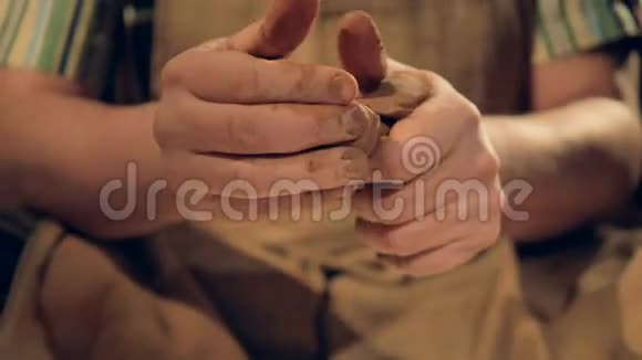 在男性手指上的特写镜头揉捏棕色粘土视频的预览图