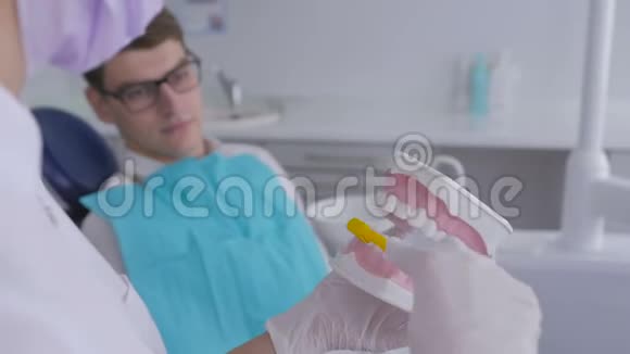 牙医使用下巴模拟和牙刷教病人正确清洁牙齿视频的预览图
