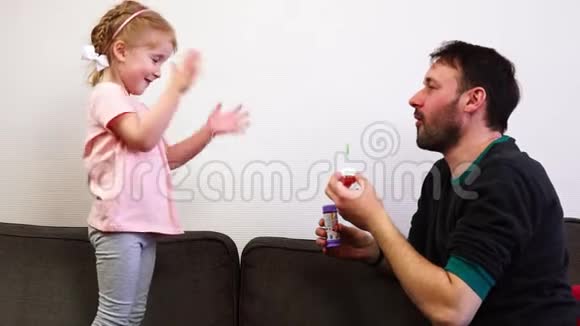 爸爸给他可爱的女儿吹肥皂泡视频的预览图