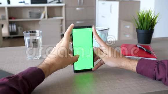 多利滑块镜头男性手浏览智能手机与绿色屏幕色度模拟视频的预览图