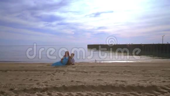 爱情夫妻在海滩上放松爱夫妻海滩一对躺在海滩上的孕妇视频的预览图