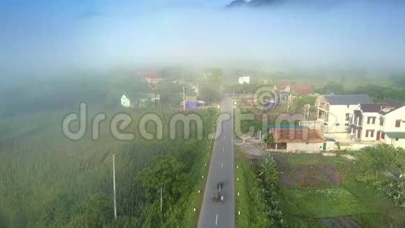 在道路和村庄房屋上方的运动与雾蒙蒙的地平线视频的预览图