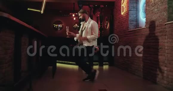 酒吧里有魅力的男人带着彩灯快乐地跳舞喝着香槟视频的预览图