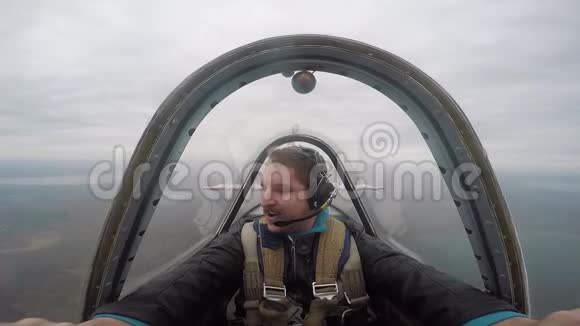 微笑飞行员坐在驾驶舱内的一架轻型特技飞行飞机情绪来自飞行特技飞行视频的预览图