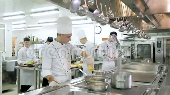 厨师在餐厅或酒店厨房的炉子上准备饭菜视频的预览图