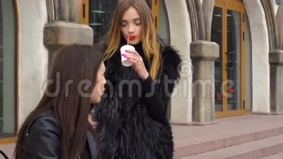 两个可爱的女孩在街上聊天喝咖啡视频的预览图