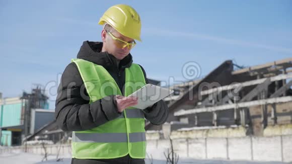 戴安全帽的工程师正在一家工业工厂使用平板电脑视频的预览图
