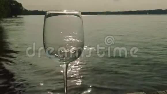 白葡萄酒倒入杯中背景是湖水视频的预览图