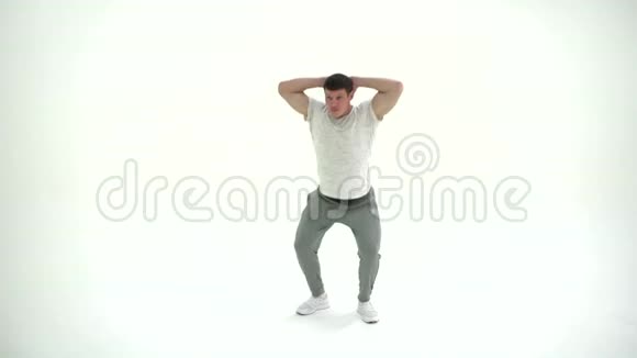 健身运动员男子蹲在工作室锻炼在白色背景4K视频的预览图