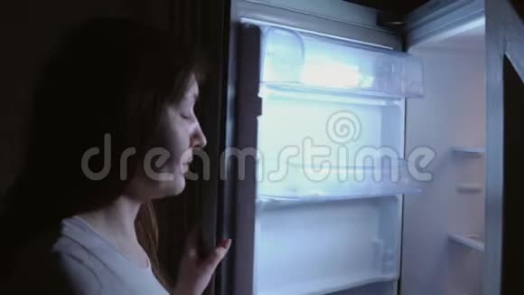 晚上冰箱里的年轻女子视频的预览图