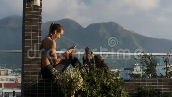女人在山上的露台上看电话留言视频的预览图